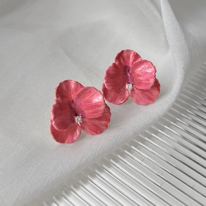 Detailed macro view of 14K gold plated orchid earrings with magenta enamel and zircon