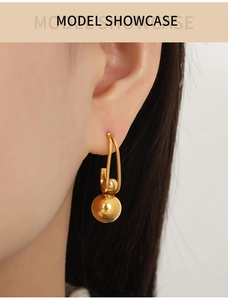 Model showcase featuring gold titanium steel drop earrings with bead pendant and J design