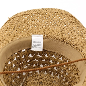 Macro view showing the internal sweatband and 100% paper straw material label of the hat