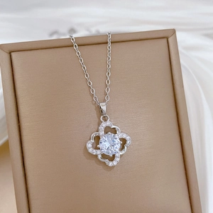 Close-up of silver hollow four-leaf clover pendant with sparkling cubic zirconia crystals