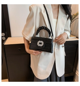Detail of black faux crocodile skin bag with crystal buckle and ruched handle