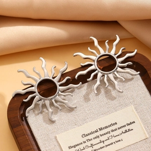 Detailed view of silver sunburst earrings on an elegant display tray and fabric