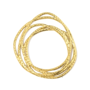 Detail of stacked gold bangles with beaded texture and polished stainless steel finish