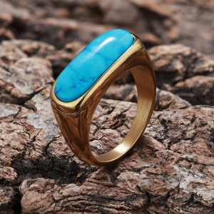 Macro view of vintage gold ring with turquoise stone set against a natural wood bark texture