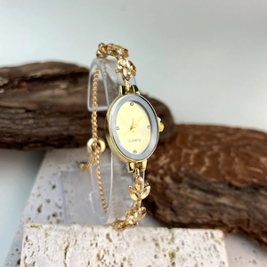 Detail of oval gold bracelet watch with crystal leaf links and quartz dial on stone