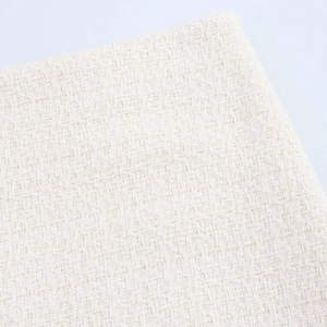 Detailed macro view of the beige tweed fabric texture on a women's two-piece set