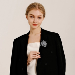 Elegant sunburst snowflake brooch with crystal and dark gemstone on black suit