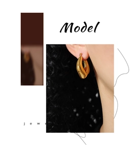 Close-up of a model wearing a polished gold geometric chunky hoop earring