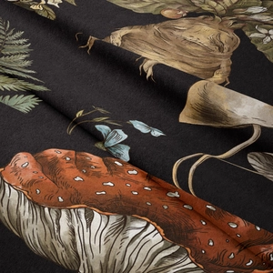 Close-up of vintage mushroom and butterfly print texture on black bohemian tapestry fabric