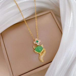 Macro shot of green fox pendant necklace featuring cubic zirconia and gold plating