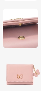 Close-up of pink leather wallet featuring a bow-shaped metal clasp and snap button detail
