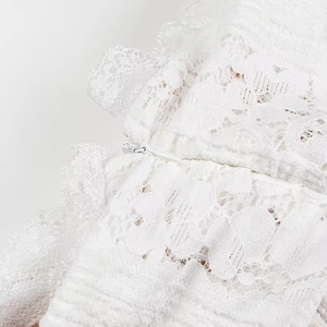 Close-up of white lace fabric texture and invisible zipper on a long tube top dress