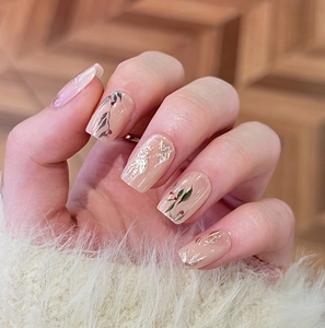 Detailed macro view of cherry and leaf nail art with gold foil on square press-on nails