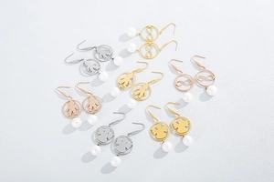 Macro detail of stainless steel earrings with pearl drops and creative hollow designs