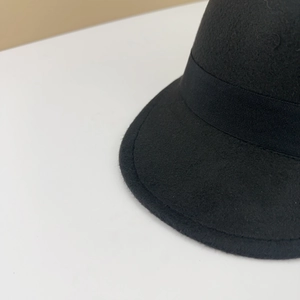 Detailed macro shot of a black wool felt equestrian hat with elegant grosgrain ribbon trim