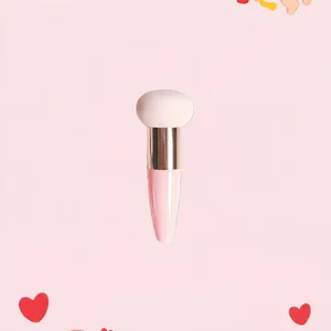 Macro shot of a mushroom head sponge makeup brush with pink handle and silver ferrule