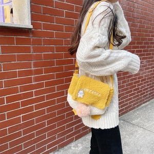 Close-up of lamb wool duck crossbody bag with SOZAKKA embroidery and plush pom-pom