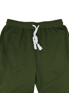 Detail of dark green knit pants with diamond texture and white braided cotton drawstring