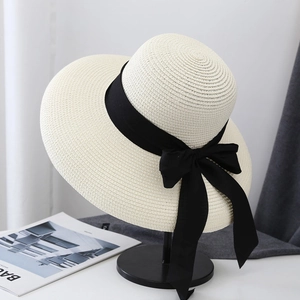 Elegant wide brim straw sun hat with black ribbon bow for summer beach vacation