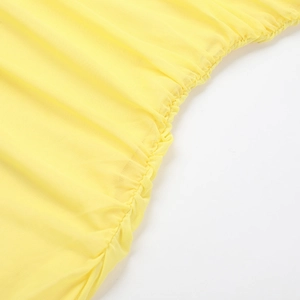 Détail macro du tissu en maille jaune vif montrant la texture plissée et froncée