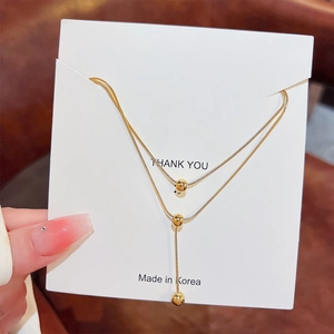 Double-layered gold snake chain necklace with polished beads in minimalist luxury style