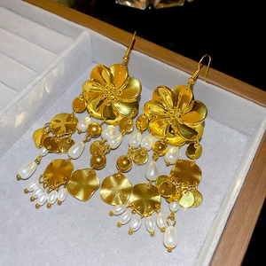 Detail von Vintage-Ohrhängern mit goldenen Blüten und weißen Perlen-Quasten