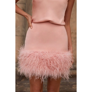 Vue détaillée d'une mini-jupe rose avec bordure en plumes de luxe et tissu satiné lisse