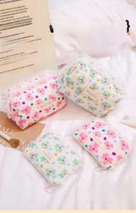 Detail of floral quilted cosmetic bags with white lace trim and branded leather tag