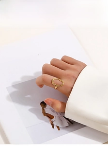 Minimalist 18K gold-plated oval cutout ring displayed on a model's finger with a modern style