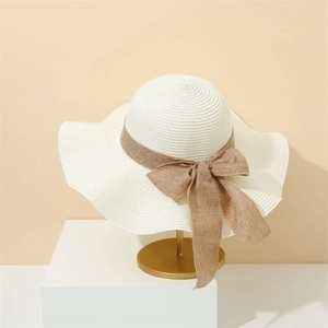 Elegant wide brim straw sun hat with brown bow ribbon for summer beach vacation