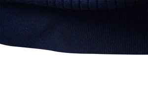 Detail shot of navy blue ribbed knit texture on a men's polo sweater hem and cuff