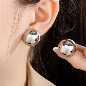 Detailansicht großer polierter silberner Kugelohrstecker im minimalistischen Stil