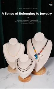 Three-piece set of beige velvet necklace busts with wooden bases for jewelry display