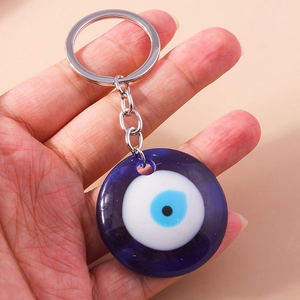 Handheld view of evil eye keychain with deep blue glass charm and silver ring