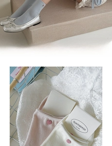 Detail of soft cream cotton socks with decorative buttons and Mary Jane shoes
