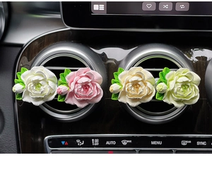 Detail view of four floral car aroma diffusers in pastel colors on air vents