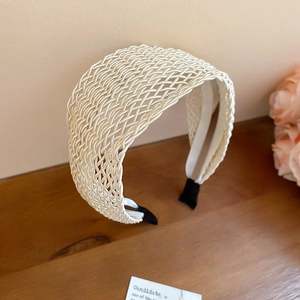 Detail of cream woven headband with cross-stitch texture and soft protective end tips