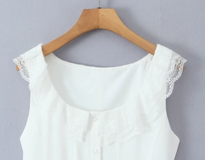 Close-up of elegant white lace trim detail and buttoned neckline on a sleeveless top