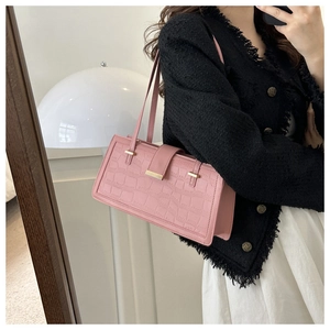 Detailed view of pink rectangular shoulder bag with crocodile pattern and golden metal accent