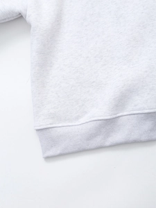 Close-up of the light gray marl sweatshirt's ribbed hem and cotton-blend knit fabric