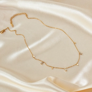 Elegant gold stainless steel necklace with square zircon charms on champagne silk