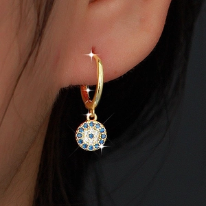 Close-up of gold S925 sterling silver hoop earring with blue evil eye pendant on ear
