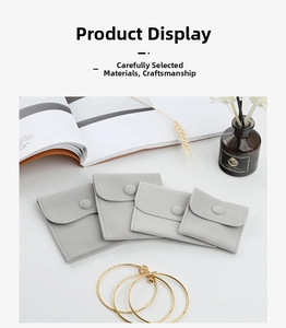 Detailed view of grey velvet jewelry pouches with snap buttons in multiple sizes