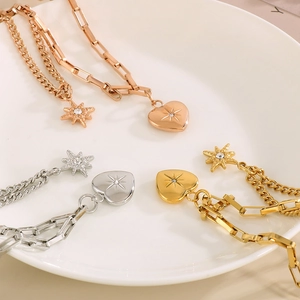 Detail of layered titanium steel necklaces with star and heart pendants in three colors