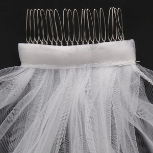 White bridal tulle veil with silver metal hair comb detail over a black background