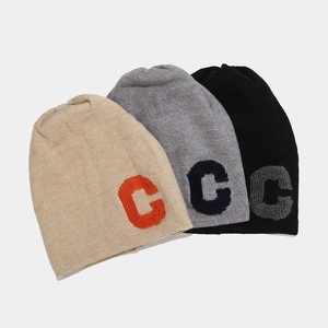 Detail view of knit beanies in beige, grey, and black featuring 3D letter C embroidery