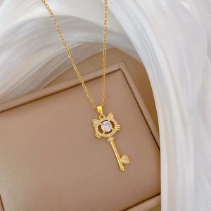 Detailed macro view of a gold cat-head key pendant with sparkling zircons on a jewelry box