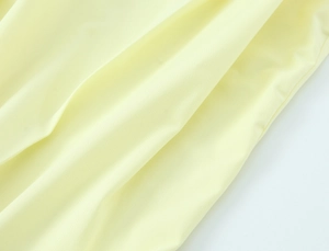 Makro-Detail der hellgelben Leinwandbindung mit hochwertiger Textur und Faltenwurf