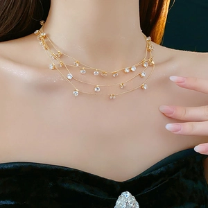 Gros plan d'un collier doré multicouche avec pendentifs en zircone sur un modèle