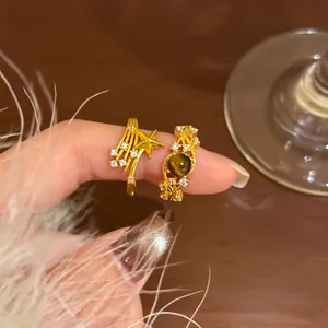 Details von 18K vergoldeten Vintage-Ringen mit Sterndesign und braunem Edelstein am Finger